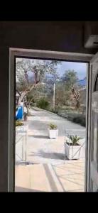 ein Fenster mit Blick auf eine Straße mit Pflanzen in der Unterkunft VANGJELIS HOTEL in Himarë