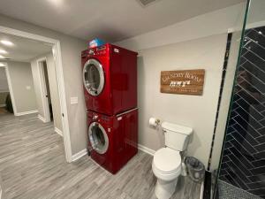 a bathroom with a red washing machine next to a toilet at Hilltop Haven w/Creek&Waterfall Dntwn McCaysville in McCaysville