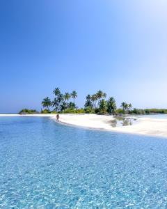 an island in the ocean with a person on the beach at Hide Inn Blue in Nilandhoo