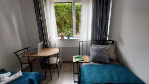 a room with a bed and a table and a window at Apartament Kopytko in Bielsko-Biała