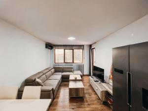 a living room with a couch and a tv at O3 Apartments in Tivat