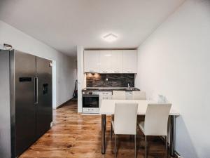 a kitchen with a white table and white chairs at O3 Apartments in Tivat