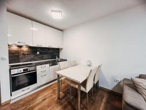 a kitchen with a table and chairs in a room at O3 Apartments in Tivat