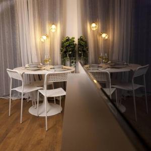 un tavolo con sedie bianche e un tavolo bianco con bicchieri di No.15 Fivedom - Luxury apartment a Southampton