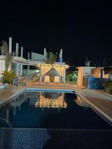 a swimming pool at night with a gazebo at Vereda linda in Juan de Acosta