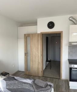 ein Schlafzimmer mit einer Tür zu einer Küche mit einer Uhr an der Wand in der Unterkunft Apartmán U Tedyho in Kašperské Hory