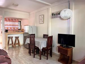 une cuisine avec une table et des chaises ainsi qu'une télévision dans l'établissement Family Hotel, à Puerto Viejo