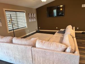 a large couch in a living room with a window at Petit Domicile Rare Deluxe Family King with Shared Bathroom in Lincoln