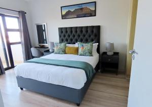 a bedroom with a large bed with a black headboard at Cape Town Luxury Stays Knightsbridge Luxury Apartment Century City in Cape Town +36 photos