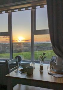 a table with a view of the sunset from a window at Sea Crest B&B Rossnowlagh in Rossnowlagh