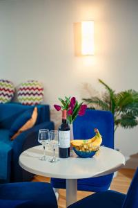 Panorama Batumi Beach Resort في باتومي: طاولة مع زجاجة من النبيذ وصحن من الفاكهة