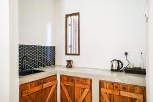 eine Küche mit Holzschränken, einem Waschbecken und einem Fenster in der Unterkunft Summer House - Private villa close to International Airport BIA in Ja-Ela