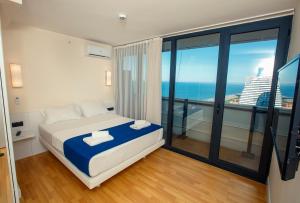 Panorama Batumi Beach Resort في باتومي: غرفة نوم مع سرير وإطلالة على المحيط
