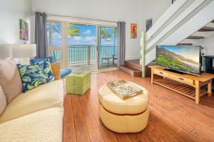 a living room with a couch and a tv at 1BR Condo at Oceanfront Resort Kapaa Shore in Kapaa
