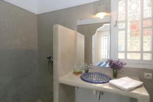 ein Bad mit einem Waschbecken und einem Spiegel in der Unterkunft Villa vue mer Mirleft - ménage et Cuisinière à mi-temps in Mirleft