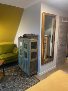 ein Wohnzimmer mit einem grünen Sofa und einem Spiegel in der Unterkunft Hotel & Gasthof Zur Linde in Middelhagen