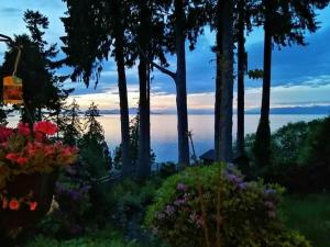 a view of the ocean from a garden with flowers at Waterfront Eagle Nest in Nanaimo