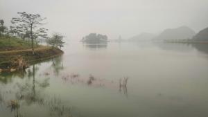 a large body of water with trees in the middle at Mai Home Ninh Bình in Ninh Binh