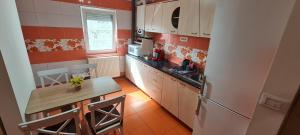 a small kitchen with a table and a refrigerator at La Bloc Apartment in Arad