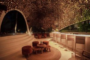 a lobby with a table and stools and a bar at Hotel Milam in Tulum