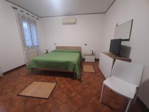 a bedroom with a green bed and a television at Locanda di Cornoleda in Cinto Euganeo