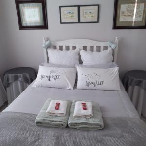 ein Schlafzimmer mit einem Bett mit zwei Handtüchern darauf in der Unterkunft Hinterheim in Lambertʼs Bay