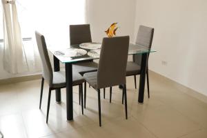 a dining room table with four chairs and a glass table at Genesis Hospedaje Yopal in Yopal