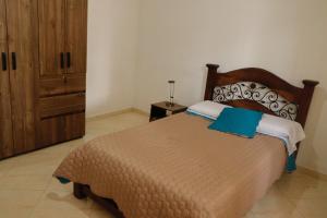 a bedroom with a large bed and a wooden cabinet at Genesis Hospedaje Yopal in Yopal