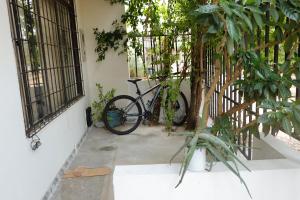 ein Fahrrad, das neben einem Gebäude mit Bäumen parkt in der Unterkunft Genesis Hospedaje Yopal in Yopal