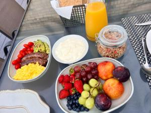 a table with plates of food and bowls of fruit at Sea Views on 14th in East London