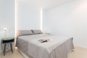a bedroom with a bed with a book on it at Oiza Garden at Alcudia beach with WIFI and AACC, BahiaBlanca in Alcudia