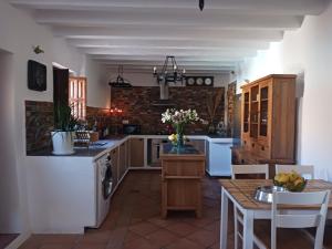 a kitchen with white appliances and a table with chairs at Cortijo rural los Cerezos pueblo Taberno in Albox