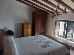a bedroom with a bed and a dresser and a window at Cortijo rural los Cerezos pueblo Taberno in Albox