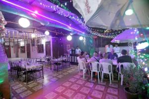 a group of people sitting at tables in a room with purple lights at Hotel Reshmi In Agra Near Chandrashekhar Park - Best Location in Agra