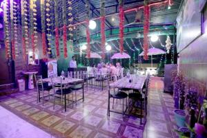 a dining room with tables and chairs and pink umbrellas at Hotel Reshmi In Agra Near Chandrashekhar Park - Best Location in Agra