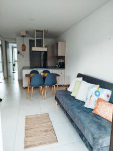 sala de estar con sofá azul y cocina en Apartamento armenia, en La Tebaida