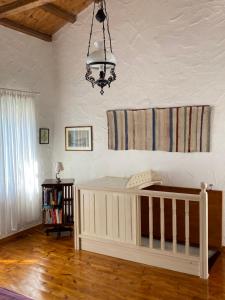 Cuna blanca en habitación con lámpara de araña en Two sisters en Alonnisos Old Town