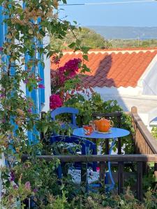 una mesa y sillas en un balcón con flores en Two sisters en Alonnisos Old Town