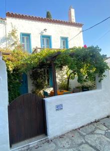 Casa blanca con puerta de madera y vides en Two sisters en Alonnisos Old Town