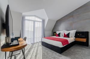 um quarto com uma cama, uma secretária e uma televisão em 2M BOUTIQUE HOTEL em Montijo