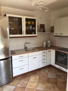 a kitchen with white cabinets and a stainless steel refrigerator at Appartement-Ferien-Messewohnung in Bad Nenndorf
