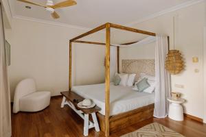 a bedroom with a canopy bed and a chair at Bello Blu Estate Luxury Mediterranean Villa in Asgourou +53 photos