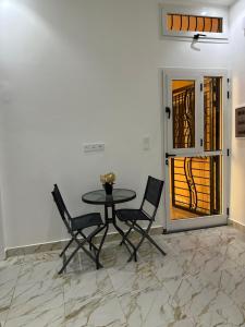 a table and chairs in a room with a door at Kyra’s place in Rufisque