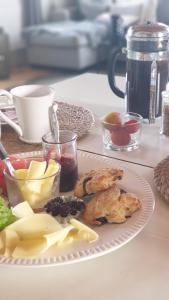 Ronehamn Bed and Breakfast في Hemse: صحن طعام فيه خضار وفواكه على طاولة