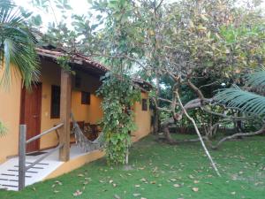 a house with a tree in front of it at Cais Dourado Pousada in Barra Grande