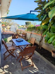 a table and chairs with a blue umbrella on a patio at A casa di Gina in Rosignano Solvay