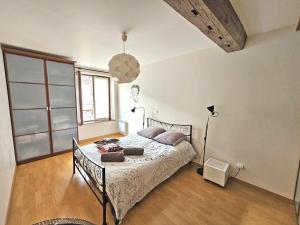 um quarto com uma cama e uma grande janela em Triplex Sisley - Maison Atypique avec Cour Extérieure em Moret-sur-Loing