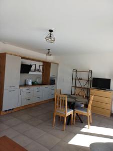 eine Küche mit einem Tisch und Stühlen im Zimmer in der Unterkunft Appartement avec Terrasse in Cléon-dʼAndran