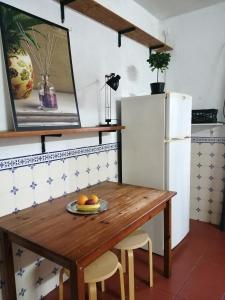 een keuken met een houten tafel en een koelkast bij Good Sleep in Santarém