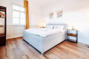 a white bedroom with a bed and a window at BackHome - Fantastische Schlosslage, SmartTV, Waschtrockner, Netflix, 50qm, 24h Checkin - Apartment 3 in Ludwigsburg